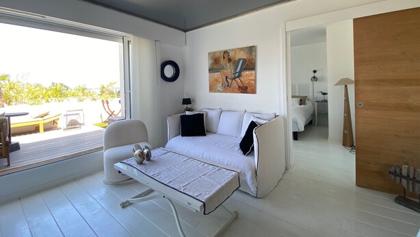 A modern bedroom with a bed, a chair, a table, and a painting on the wall. - 180° sea view-Terrace-Rooftop-Plage-City center-Fiber-Netflix-Clim-Garage   (Arcachon)