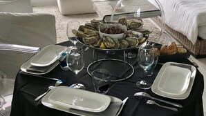 A dining table set with plates, glasses, and a bowl of oysters. - 180° sea view-Terrace-Rooftop-Plage-City center-Fiber-Netflix-Clim-Garage   (Arcachon)