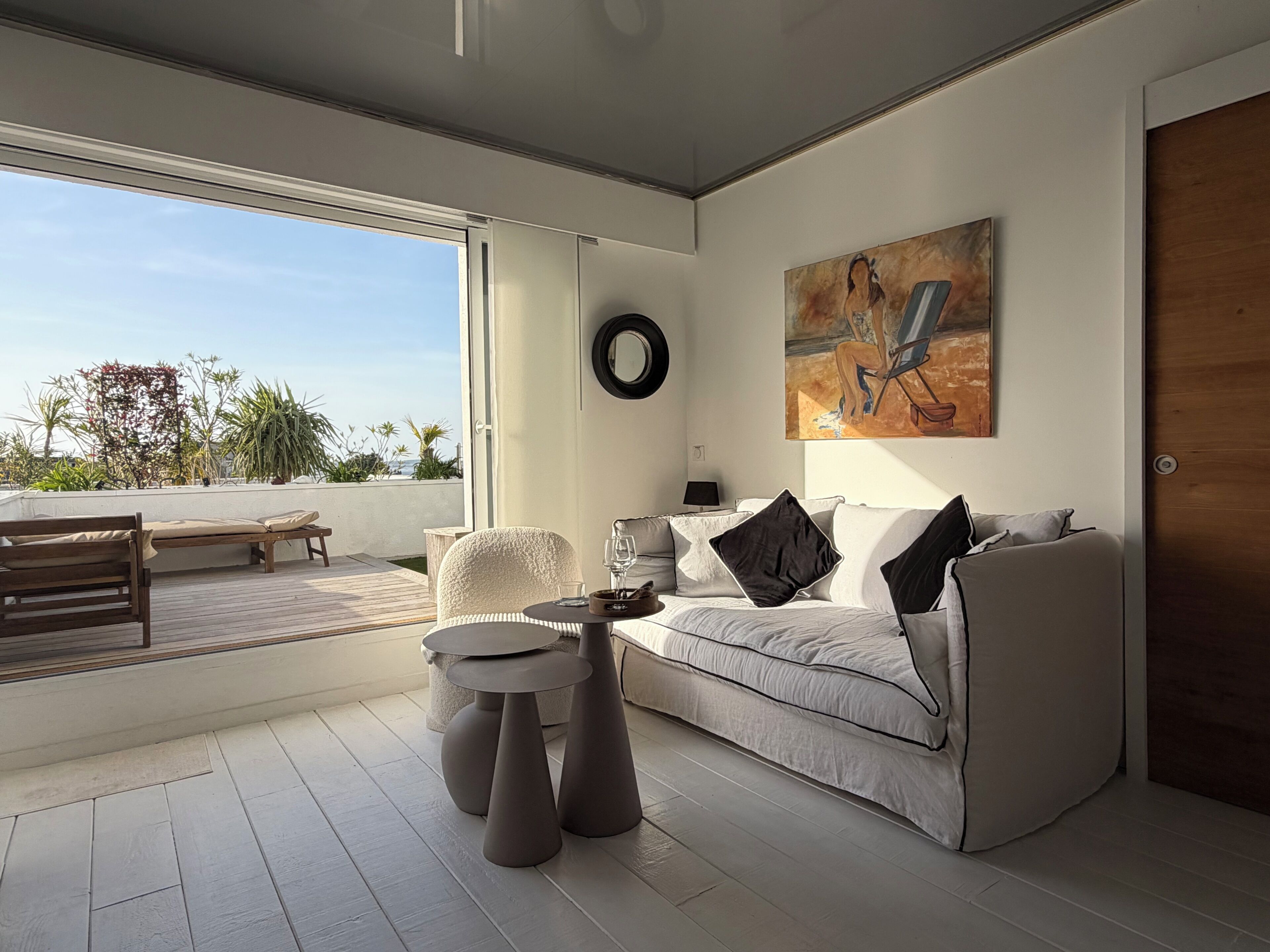 Een moderne woonkamer met een bank, salontafel en een schilderij aan de muur.