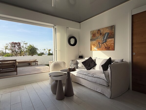 A modern living room with a sofa, coffee table, and a painting on the wall. - 180° sea view-Terrace-Rooftop-Plage-City center-Fiber-Netflix-Clim-Garage (Arcachon)