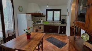 Cozinha compacta com mesa, cadeiras e um vaso de planta.
