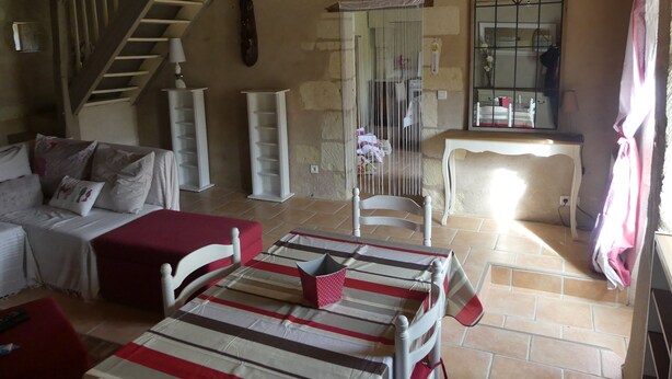 Une pièce confortable avec un escalier, un lit, une chaise et une table.