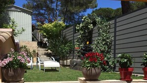 A patio area with stone steps leading to a seating area, surrounded by potted plants and a grassy lawn. - House for rent gulf of St Tropez 2 bedrooms in residence with swimming pool tennis (Gassin)