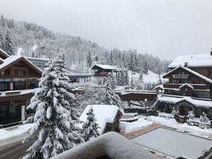 A snow-covered village with wooden buildings, including a restaurant named "La Rousseina." - Ideal for 2 couples - Parking - Housekeeping included - Linen provided. (Les Allues)