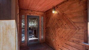 A wooden interior with a door leading to a balcony.