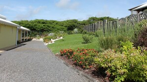 A pathway leading to a building with a yellow exterior and a covered area.