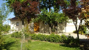 Uma casa com jardim, porta de madeira e janela.