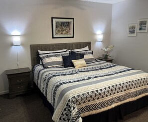 A bedroom with a bed, nightstands, and wall art. - Red Fox Property Graeagle/Blairsden (Clio)