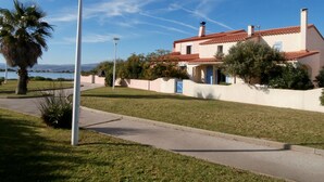 Una casa con techo de tejas rojas, puerta azul y pared exterior blanca.