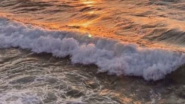 Un atardecer sobre el océano con olas.
