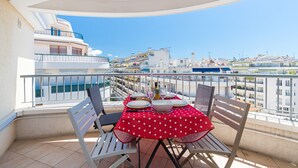 A balcony with a table set for dining, overlooking a cityscape. - Béatrice Apartment with free parking. Elevator (Nice)