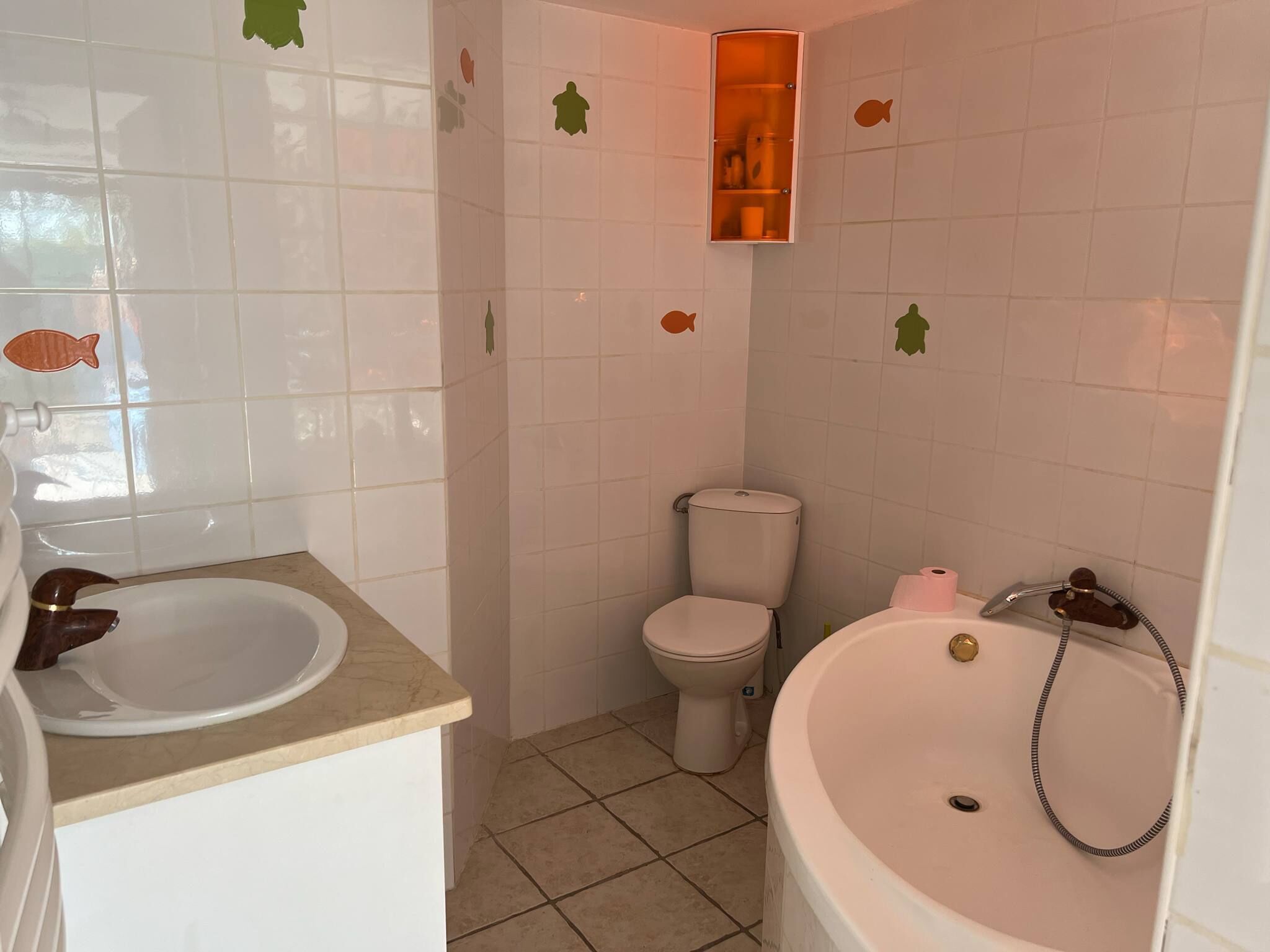 Un baño con lavamanos, inodoro y bañera.