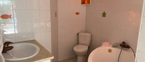 Un baño con lavamanos, inodoro y bañera.
