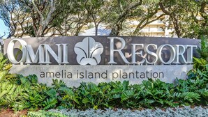 A sign for Omni Resort Amelia Island Plantation with a logo and name.