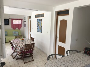 Un coin repas avec une table et des chaises, un canapé et une carte accrochée au mur.