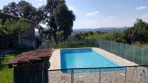 A rectangular swimming pool with a stone tile deck, surrounded by a green fence and a metal railing. - Independent MAS in the middle of vineyards in St Pons de Mauchiens, 10 km from Pézenas (Saint-Pons-De-Mauchiens)