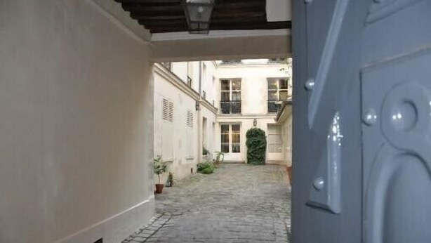 A narrow cobblestone alleyway leading to a building with a large, ornate door. - Charming studio Ile Saint Louis PARIS 4 ° ° - Paris (Paris)