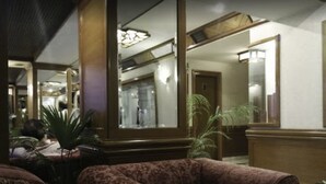 A hotel lobby with a large mirror, a sofa, and a table. - Sunfort hotel (Lahore)