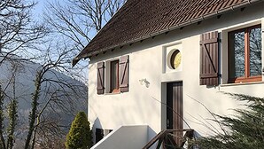 A house with a steep staircase leading to a door, surrounded by trees and hills. - Gérardmer, superb valley view, Gite ****, Internet, TV, Short Stay adm (Rochesson)