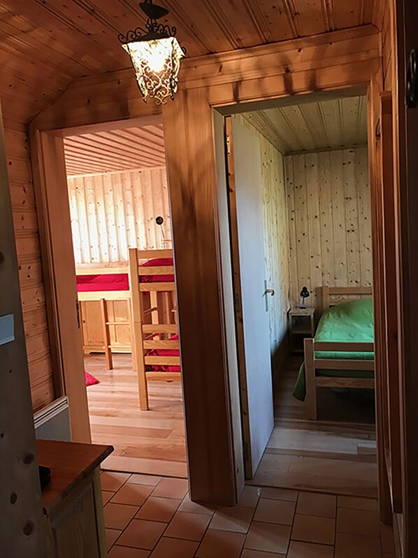 Ein Zimmer im Holzstil mit einem Bett, einem Nachttisch und einem Sessel.