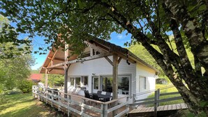Eine Holzhütte mit Terrasse, Sitzgelegenheiten im Freien und einer überdachten Veranda.