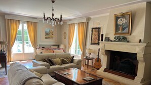 Uma sala de estar ampla com sofá, mesa de centro, lareira e um quadro na parede.