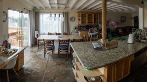 A kitchen with granite countertops, wooden cabinets, and a dining area with a table and chairs.