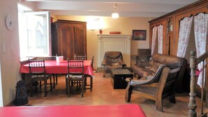 Un comedor con una mesa y sillas rojas, un sofá de cuero y una chimenea.
