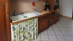 A kitchen with wooden cabinets, a sink, a microwave, and a coffee maker.