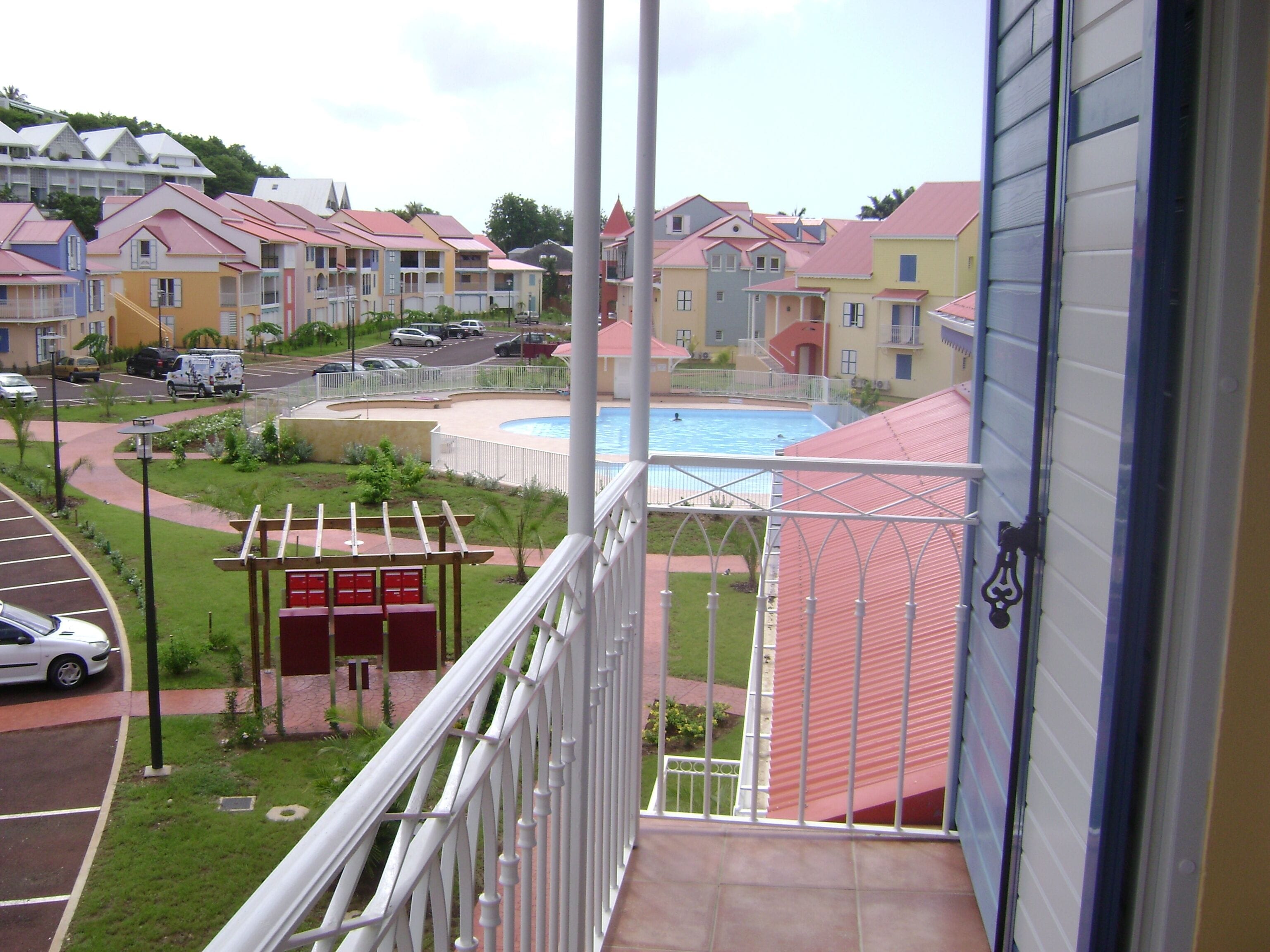 A residential area with colorful houses, a swimming pool, and a parking lot.