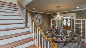 A dining area with a round table, chairs, and a chandelier. - Amazing Home & Area - Close to Downtown Nashville! Family & Group Friendly! (Nashville)