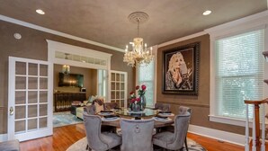 A dining area with a chandelier, a round table, and grey upholstered chairs. - Amazing Home & Area - Close to Downtown Nashville! Family & Group Friendly! (Nashville)