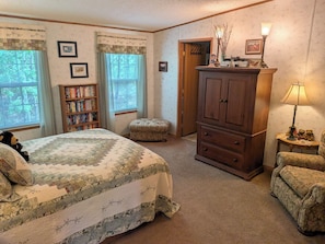 Un dormitorio con cama, estantería, armario y lámpara.