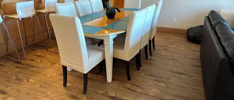 A dining area with a table, chairs, and a vase of flowers.