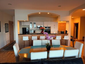 A modern kitchen with white cabinets, a built-in oven, and a microwave.