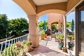 A balcony with potted plants, outdoor furniture, and a view of the surrounding greenery. - Great Condo with easy 5 minute access to beaches, downtown, and the airport (Santa Barbara)