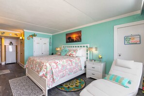 A bedroom with a bed, a nightstand, a chair, and a painting on the wall.