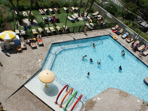 A swimming pool with multiple lanes, surrounded by lounge chairs and umbrellas. - Sea Breeze - Stunning King Suite with breathtaking views! (Myrtle Beach)