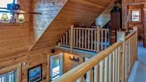 A wooden interior with a sloped ceiling, a wooden staircase with a railing, and a window with blinds. - 5 BR Log Home - 5 Min/2.7miles to TIEC - with a Hot Tub on 18 acres "Creekside"  (Rutherfordton)