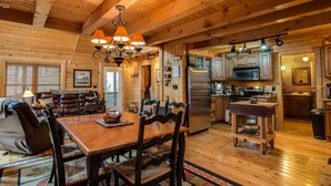 A wooden cabin interior with a dining area, kitchen, and living room. - 5 BR Log Home - 5 Min/2.7miles to TIEC - with a Hot Tub on 18 acres "Creekside"  (Rutherfordton)