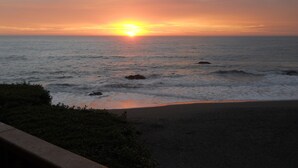 Atardecer sobre el océano con olas y una playa al frente.