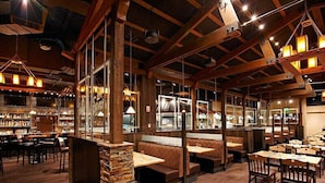 A restaurant interior with wooden beams, stone pillars, and a bar area. - Spacious Luxury Two-Bedroom at Grand Lodge at Peak 7! (Breckenridge)