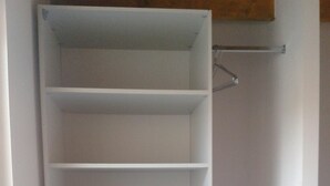 A white closet with multiple shelves and a metal rod for hanging items. - House for 6 pers. very close to the sea and shops (Agde)