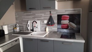 A modern kitchen with grey cabinets, a stainless steel sink, and a kettle. - House for 6 pers. very close to the sea and shops (Agde)