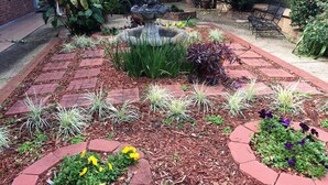 A garden with a central fountain, surrounded by brick pathways and various plants. - SUPER SUMMER SAVINGS!! ;:HOT PROPERTY (baton rouge)