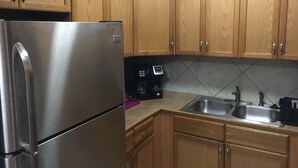A kitchen with wooden cabinets, a stainless steel refrigerator, a coffee maker, and a double sink. - SUPER SUMMER SAVINGS!! ;:HOT PROPERTY (baton rouge)