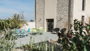 A courtyard with outdoor seating and a stone building.