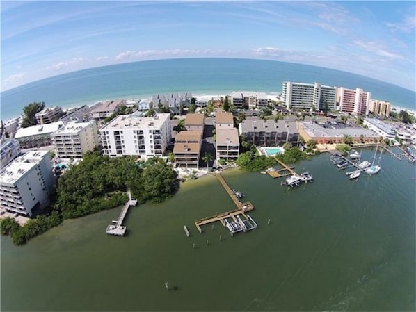 An aerial view of a coastal area with buildings, a marina, and a beach. - Newly Decorated Beach Condo. Gulf/ intercoastal access and views! (Indian Shores)