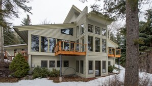 A multi-story house with a balcony on the second floor and a covered porch area. - Ski-In Family Lodge w/ Hot Tub, Game Room, Sauna & Designer Interiors (Teton Village)