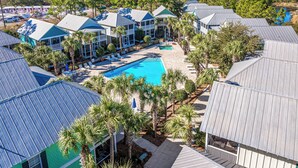Un resort con diversi edifici, piscina e palme.
